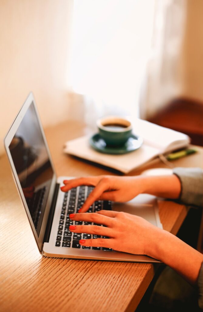 Anonymous female freelancer typing on laptop