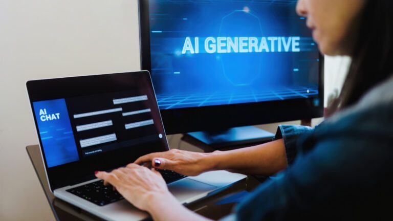 A person types on a laptop featuring an AI chat interface, while a monitor in the background prominently displays "Generative AI.