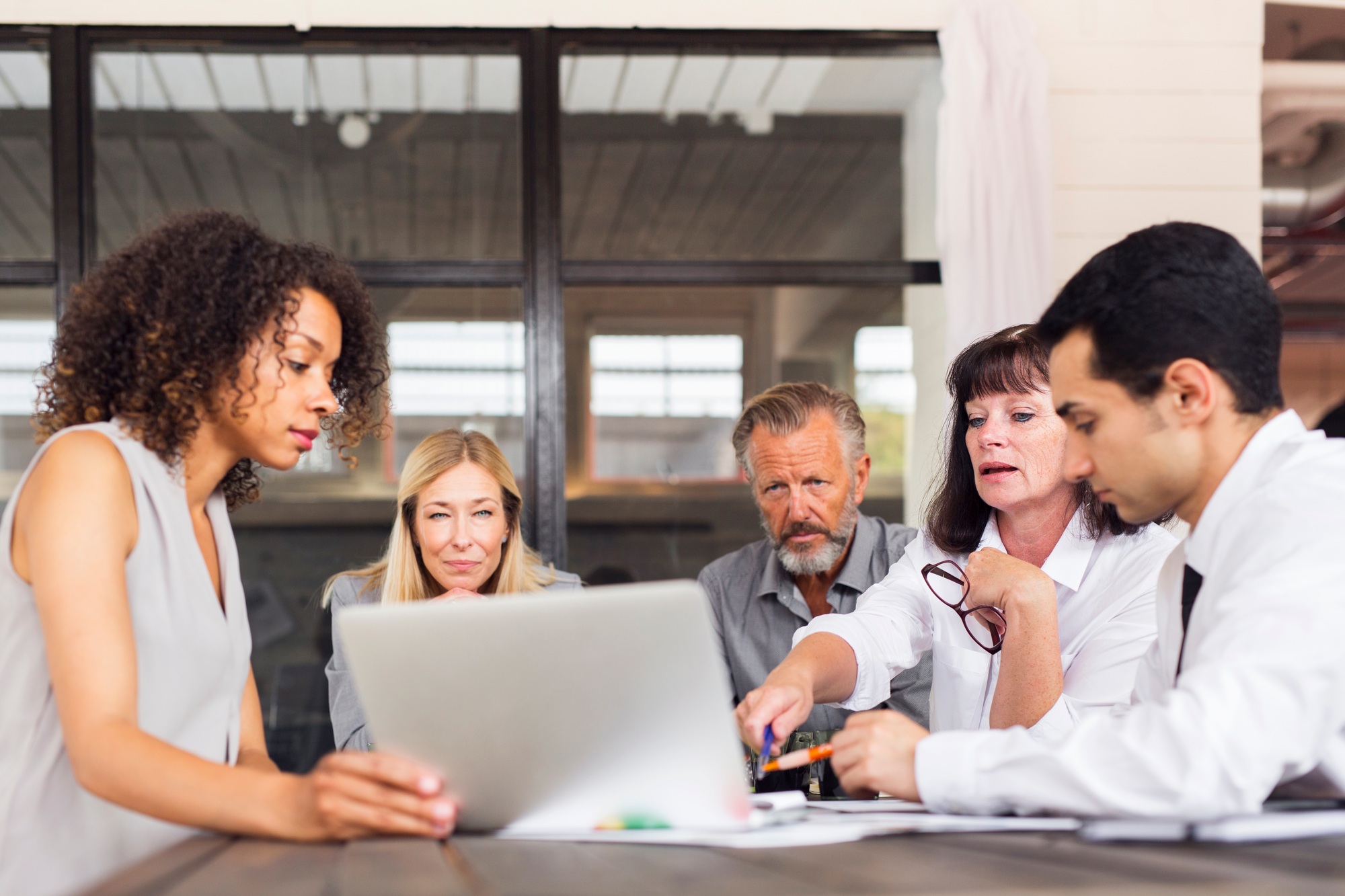 Business people using laptop at meeting in office