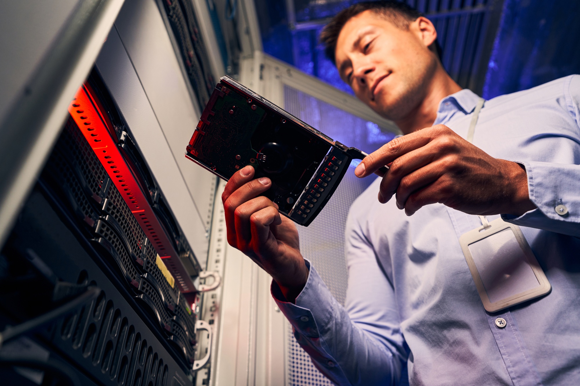 Data center IT technician examining new HDD