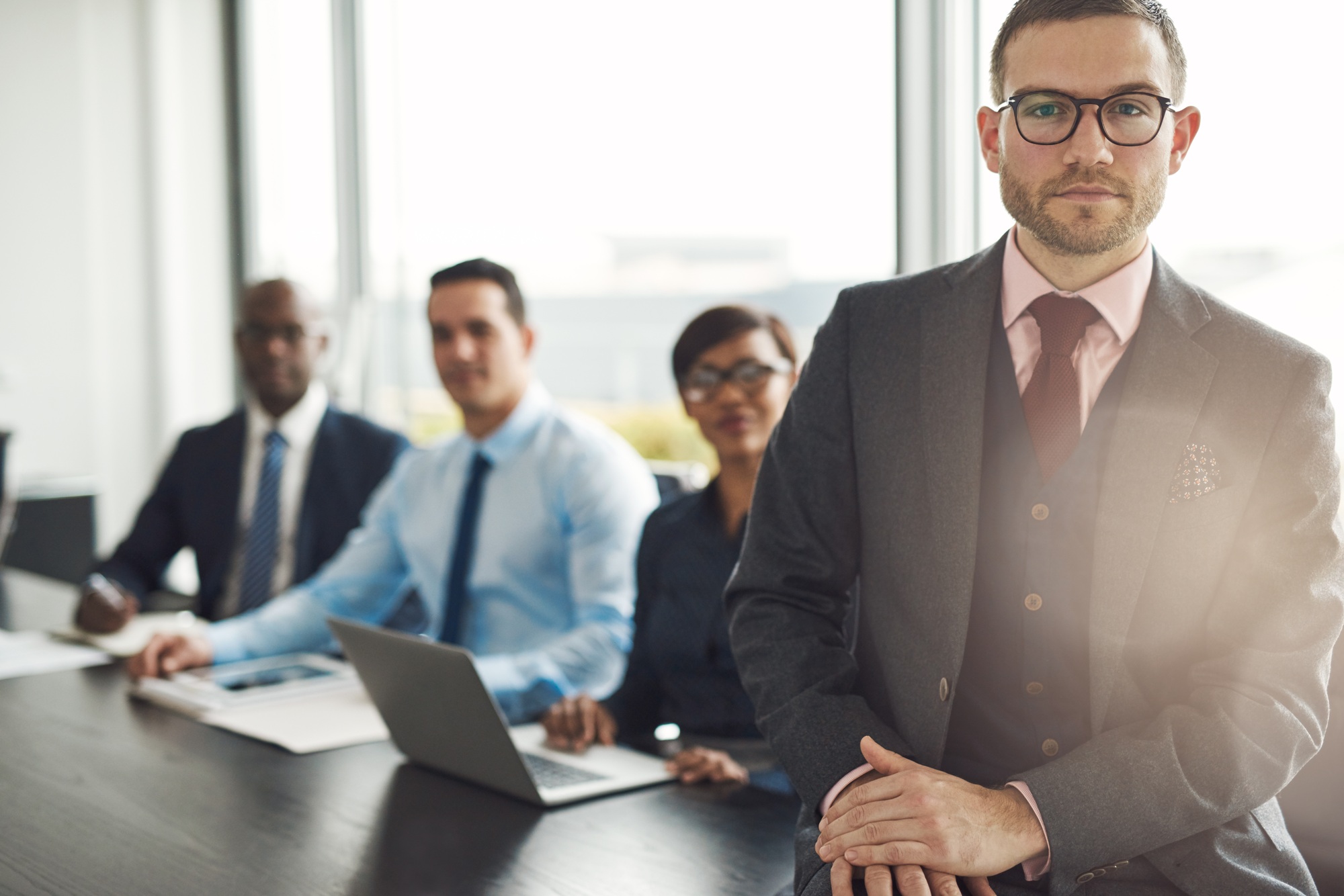 Handsome Caucasian executive with three employees