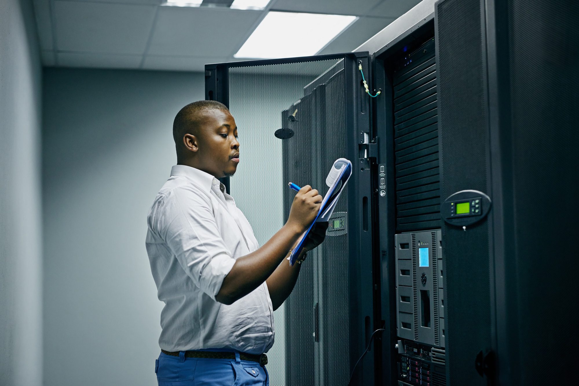 Shot of an IT technician doing inspections in a data center