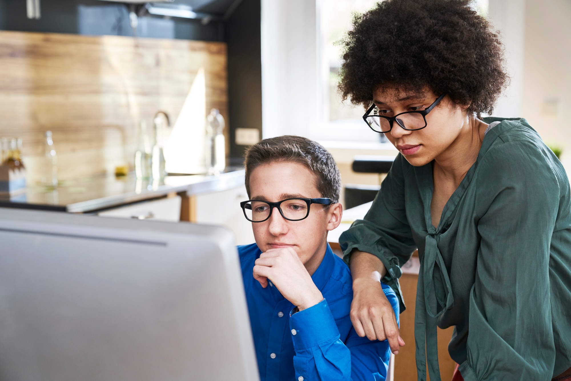 Two colleagues looking at computer monitor in office