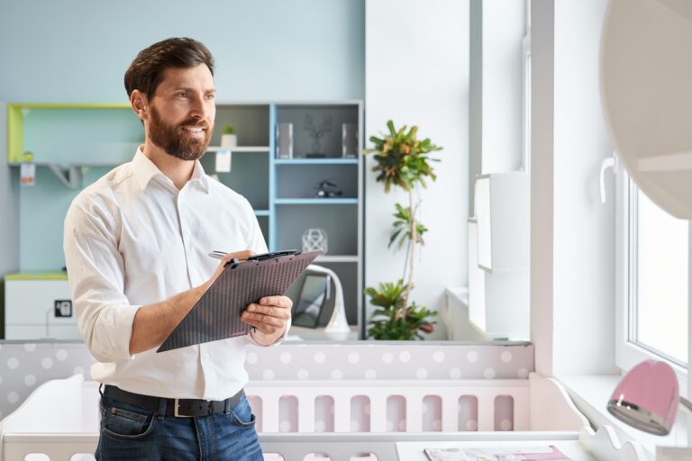 Successful sales manager writing on tablet, comparing prices, while work in furniture store.