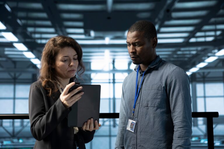 Team of programmers in data center using automation tools on tablet