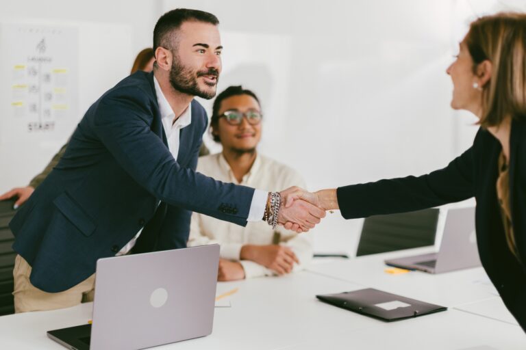 Business professionals shaking hands in office meeting