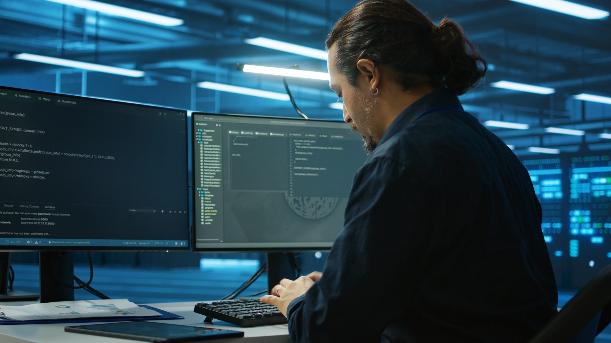 Admin focused on programming in server room on computer