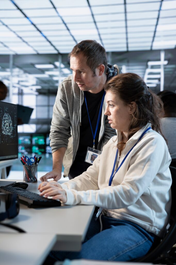 Worker requesting help from senior engineer to fix error in high tech data center